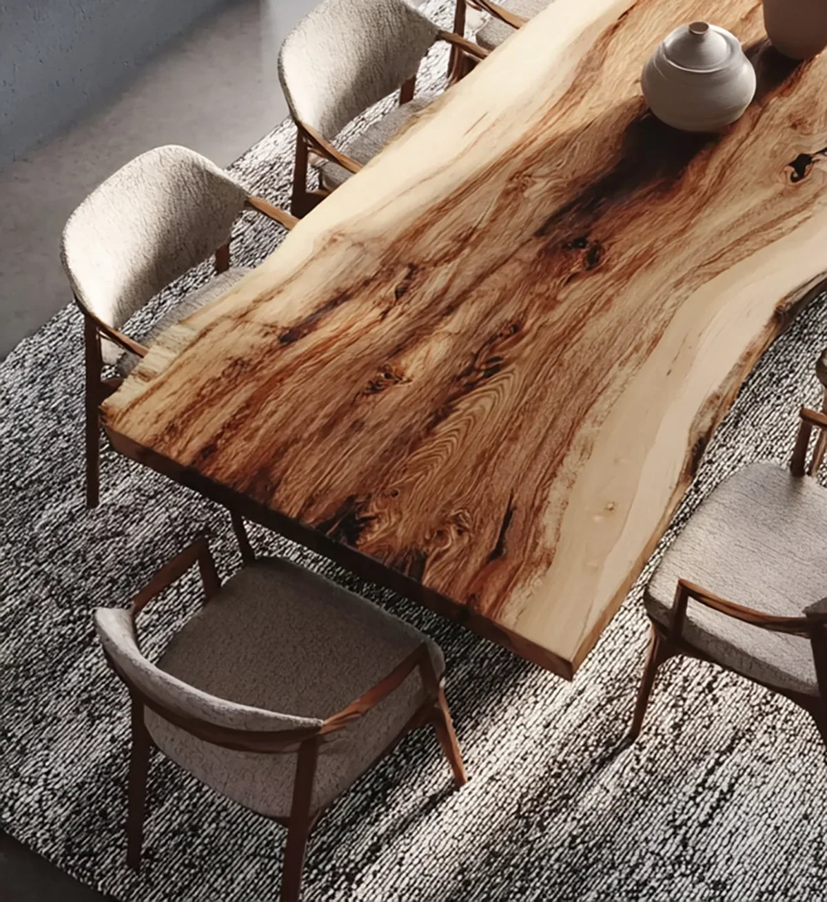 Live edge wooden dining table surrounded by modern cushioned chairs on textured rug