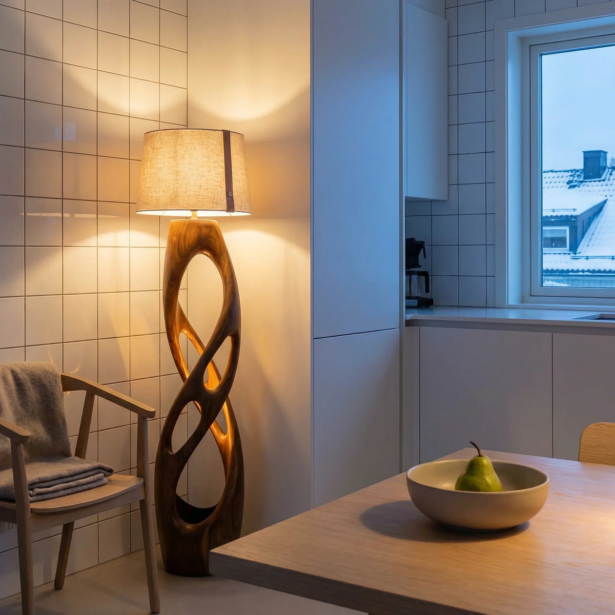 Scandinavian kitchen nook with sculpted wooden floor lamp, modern wood chair, and tiled walls.