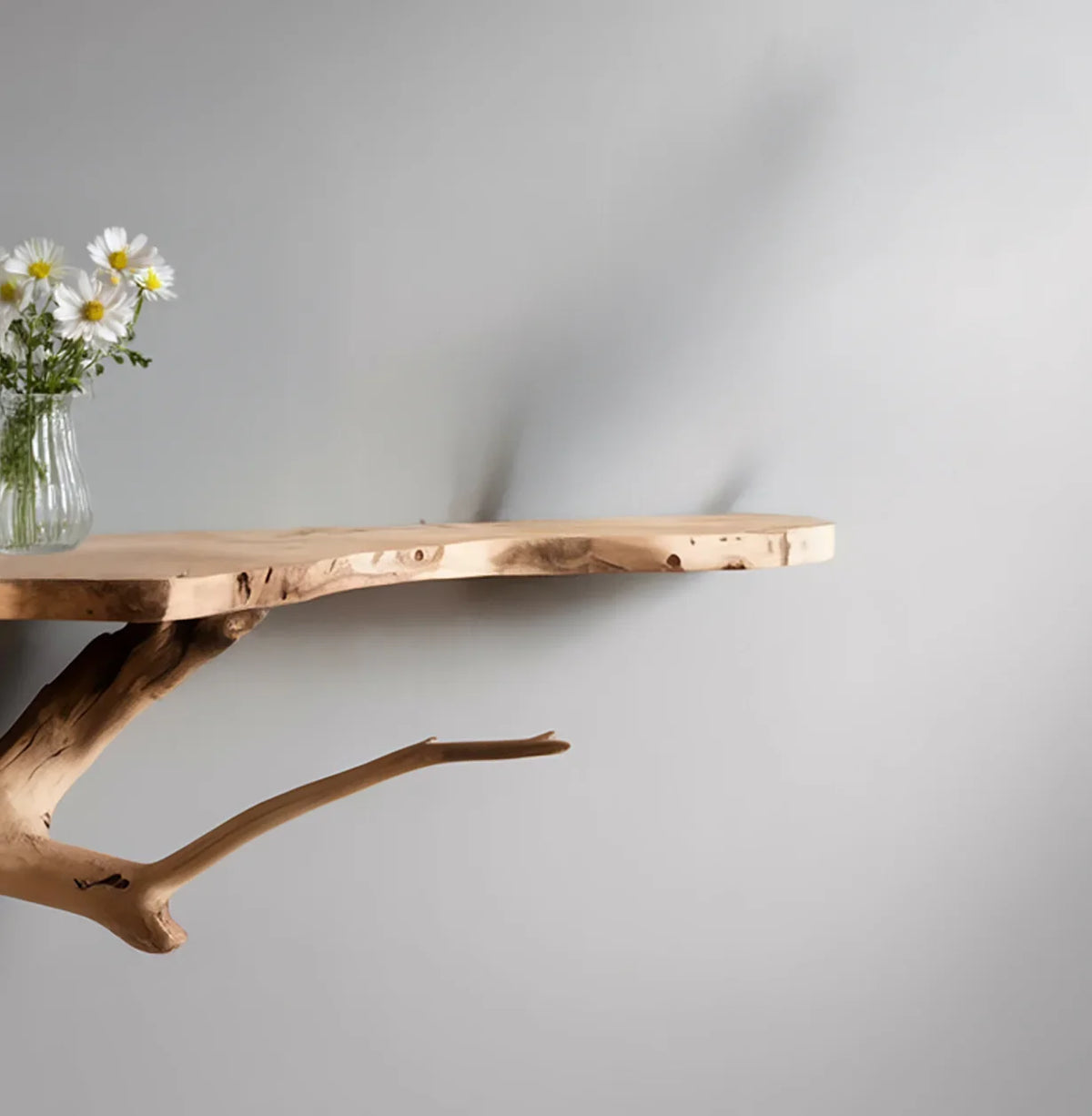 Live edge floating wood shelf with natural branch support and vase of white flowers
