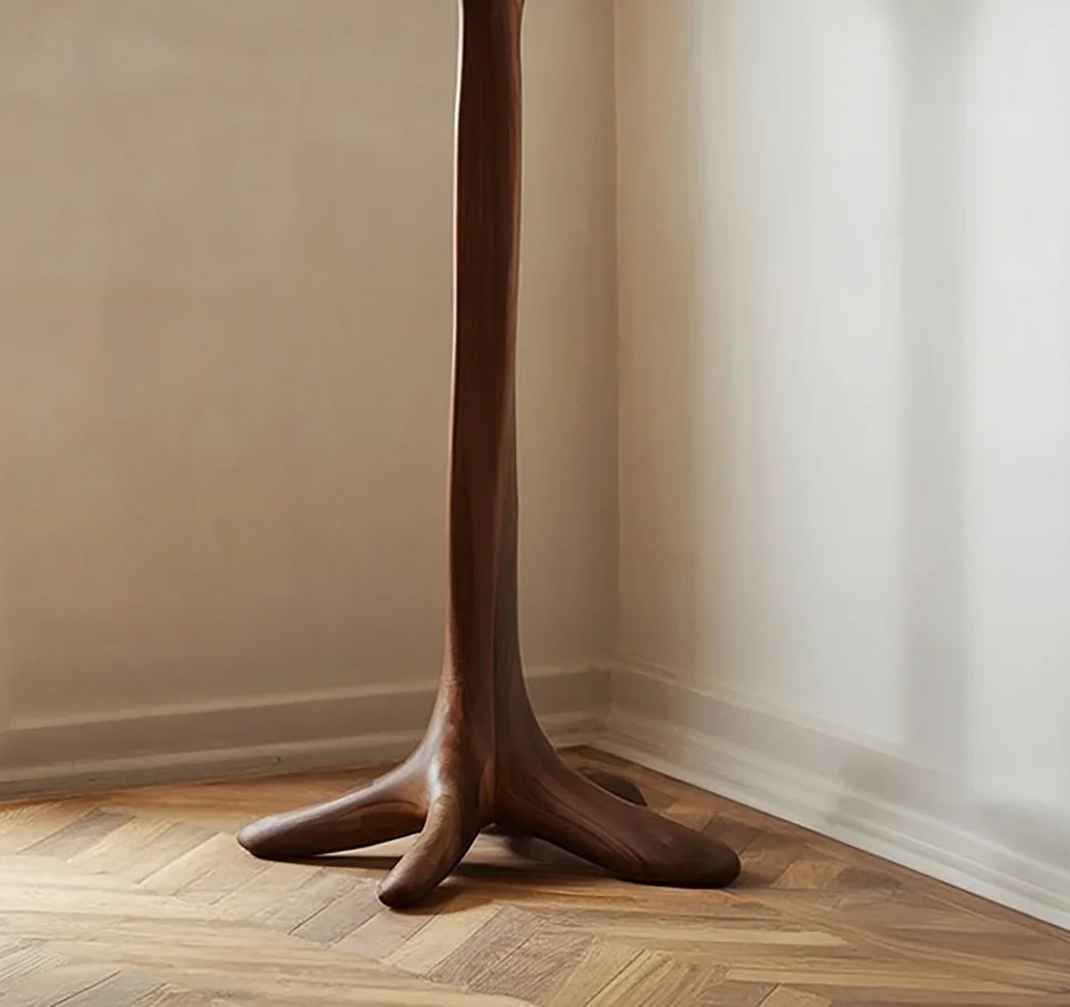 Sculptural solid wood table leg with organic, tree root-inspired base on parquet floor