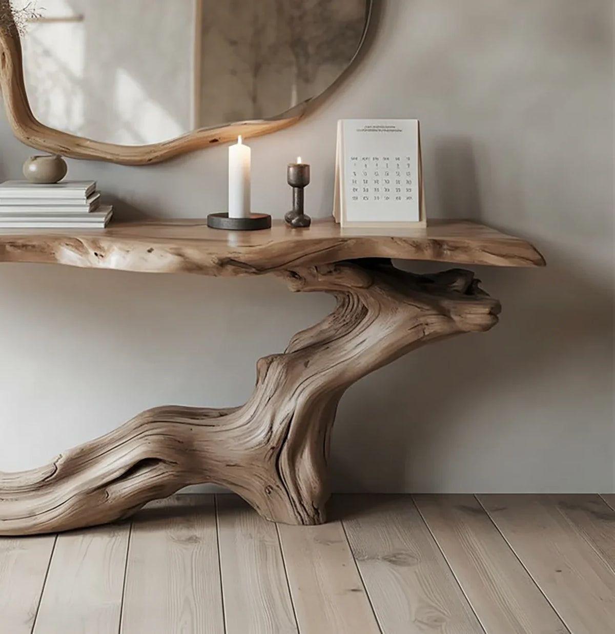 Natural wood console table with live edge, decorative candles, stacked books, and a calendar