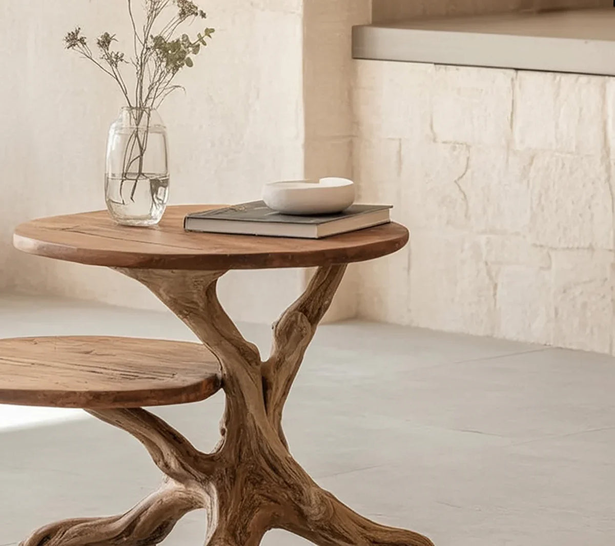 Solid wood live edge side table with natural branch base, glass vase, and books in modern interior