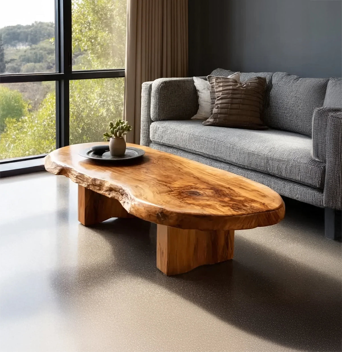 Live edge solid wood coffee table in modern living room with grey sofa and large windows
