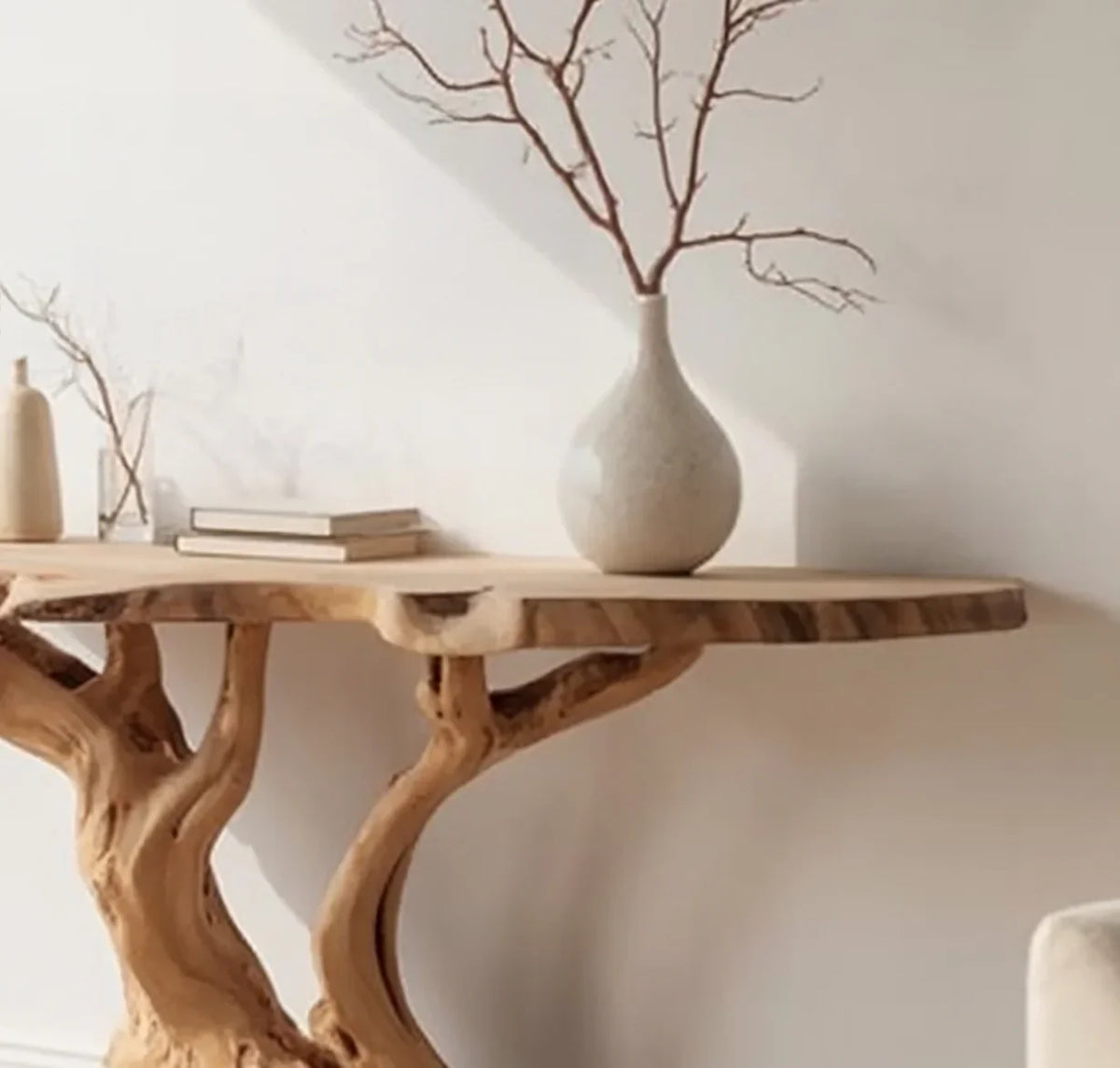 Live edge solid wood console table with sculptural base, minimalist decor, and ceramic vase