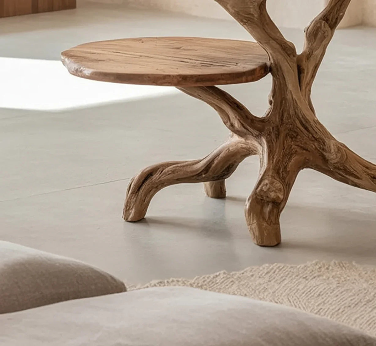 Live edge solid wood coffee table with natural tree branch base in a minimalist room