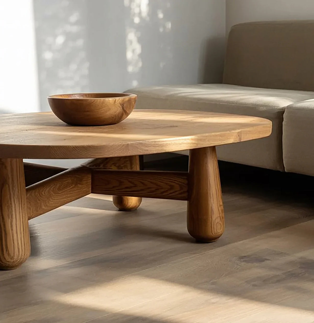 Solid wood modern coffee table with round edges and wooden bowl in a sunlit living room