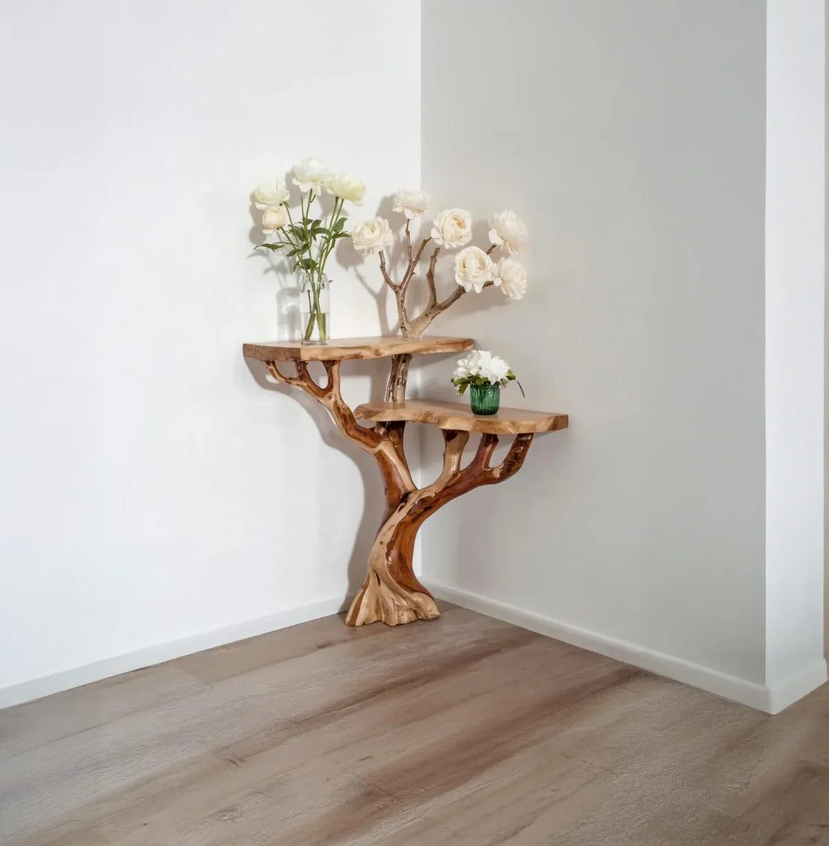 Tree bookshelf with live edge solid wood shelves in a corner, decorated with white flowers