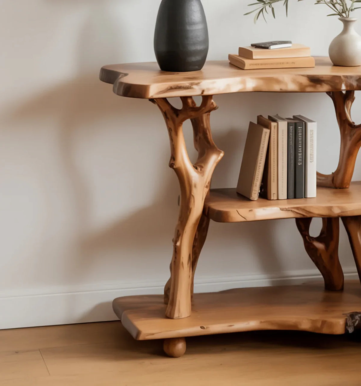 Live edge solid wood shelf with tree branch supports holding books and vases, modern decor