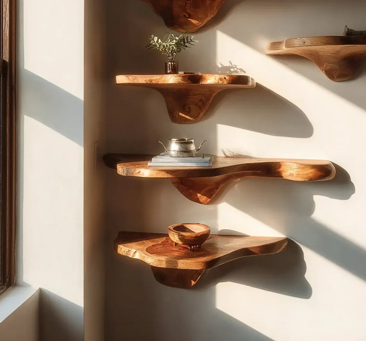 Solid wood live edge floating shelves displayed on a wall in natural sunlight.