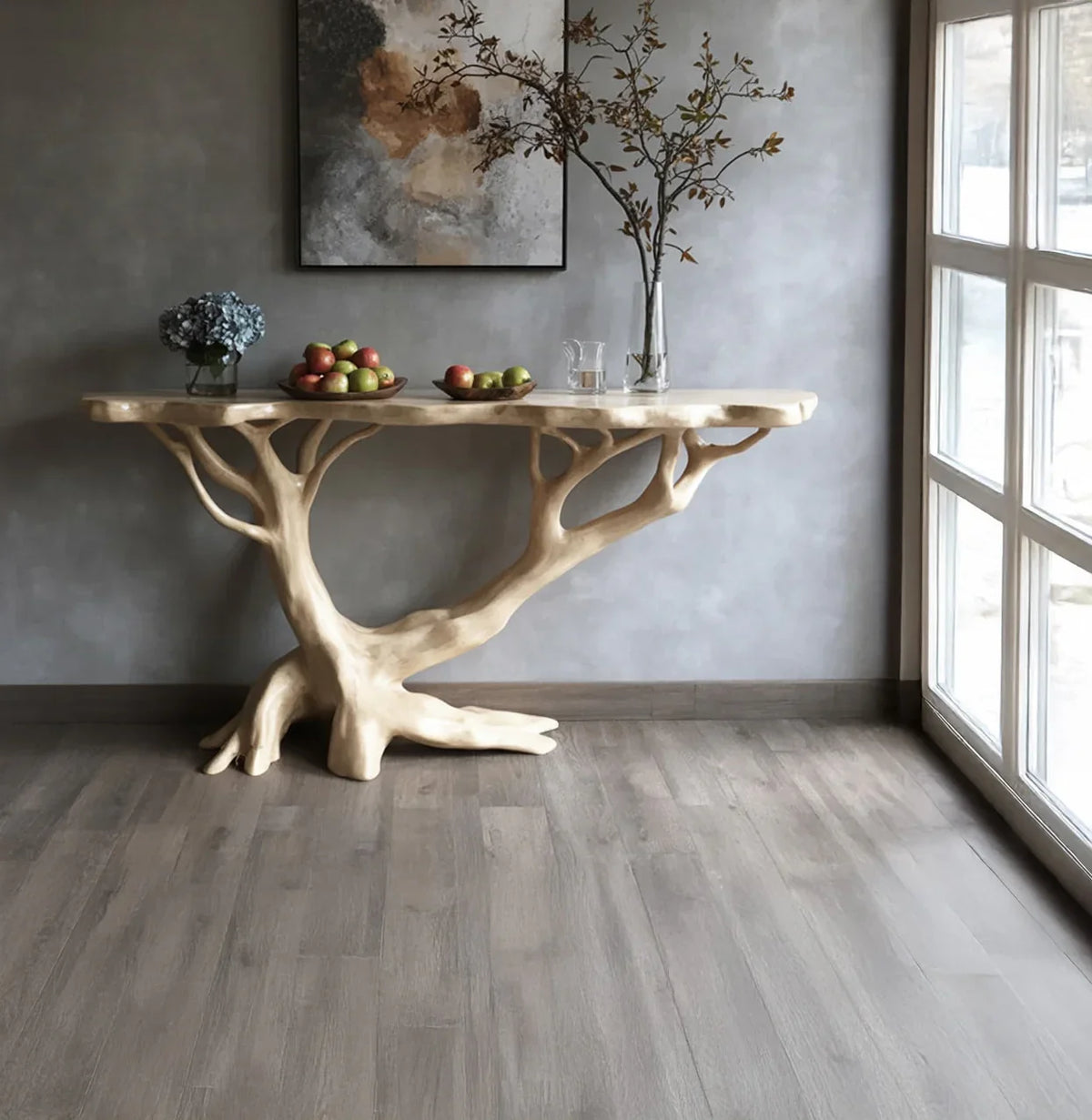 Sculpted live edge wood console table with tree-inspired base, styled with fruit and vases in modern room