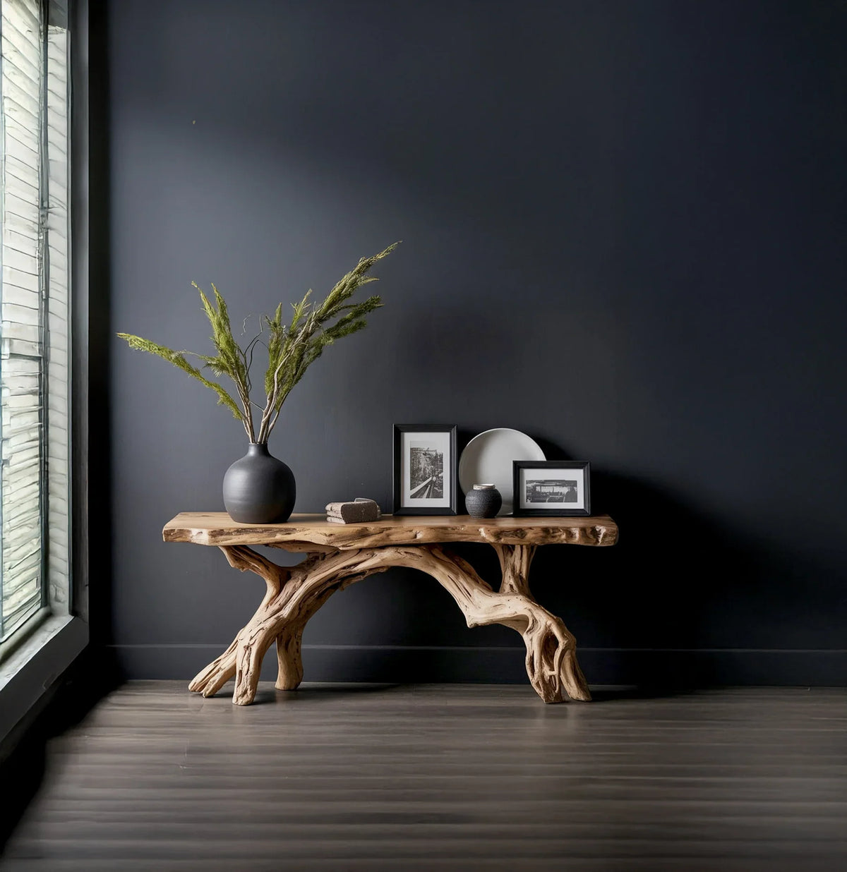 Rustic wooden console table with natural branch legs against dark gray wall, decorated with vase, photos