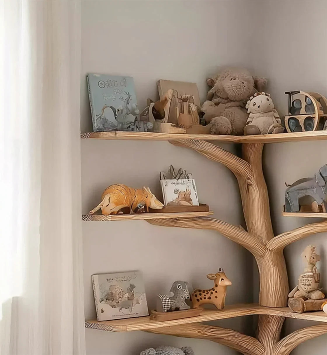 Wooden tree-shaped shelf decorated with stuffed animals, animal figurines, and children's books