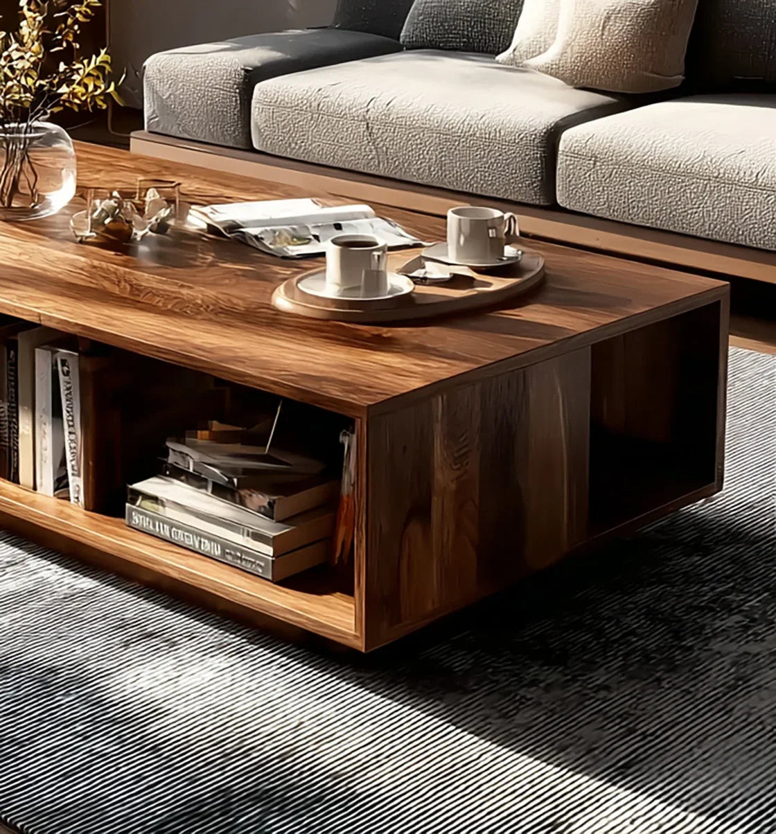 Modern wooden coffee table with books, magazines, two coffee cups on tray, near cream cushioned sofa