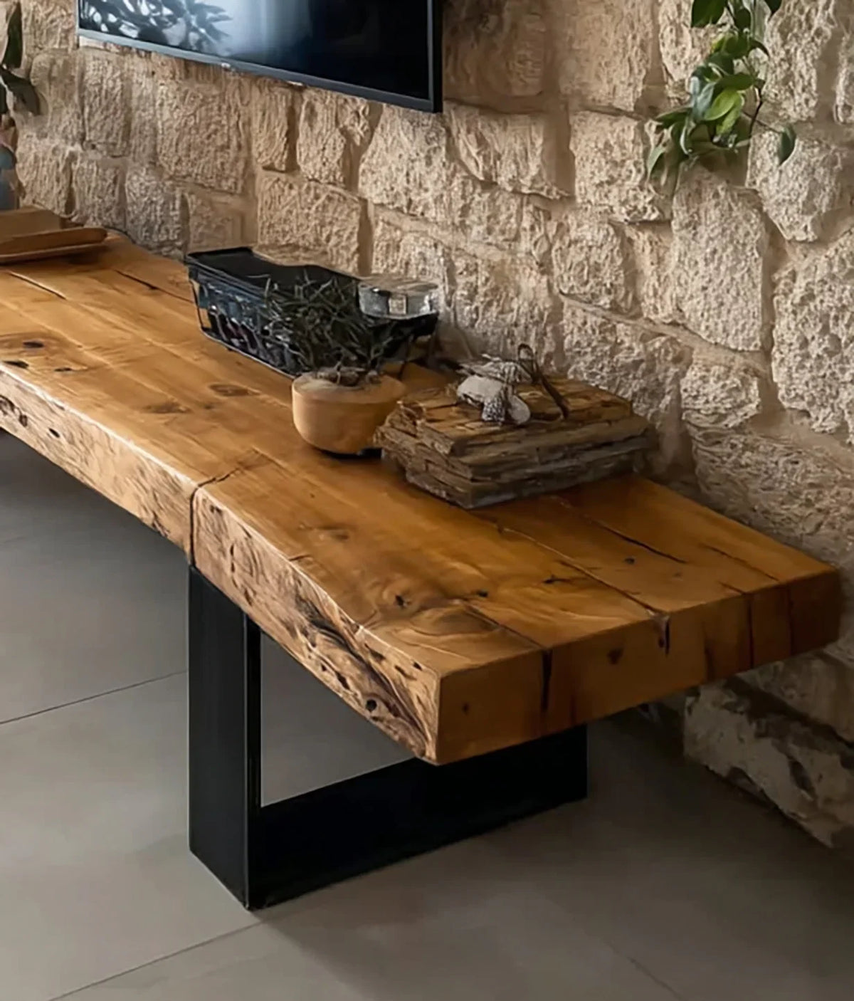 Rustic wooden console table with natural grain and plants against stone wall in modern interior