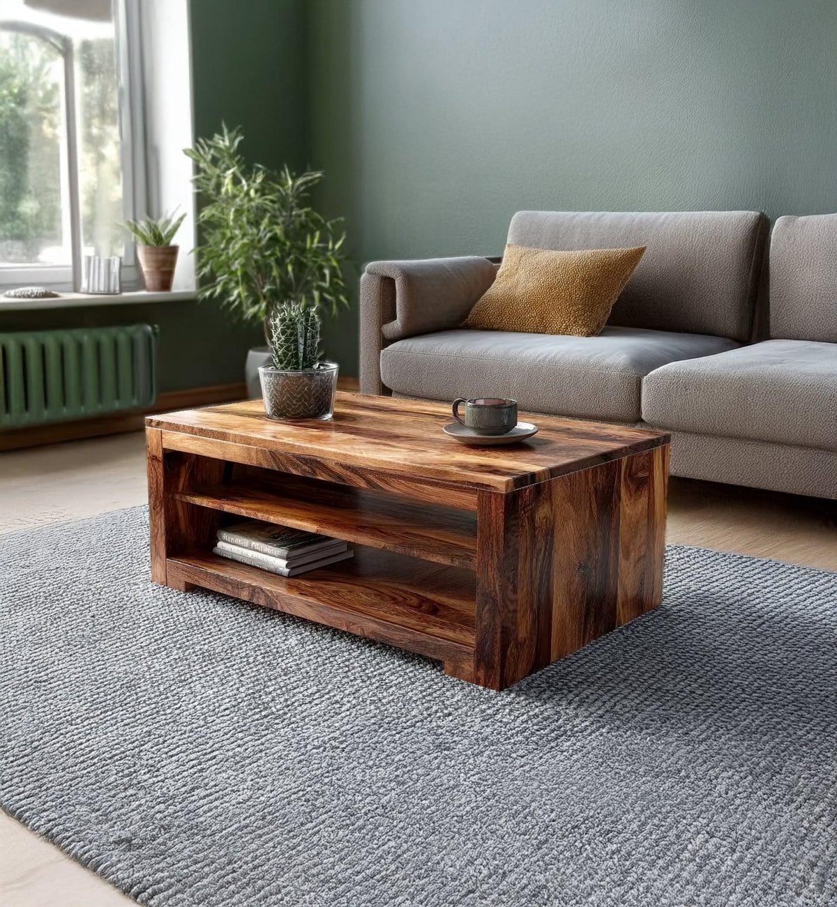 Modern living room with wooden coffee table, gray sofa, green walls, and indoor plants