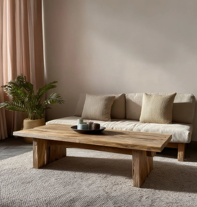 Solid wood live edge coffee table in a minimalist living room with neutral sofa and indoor plant
