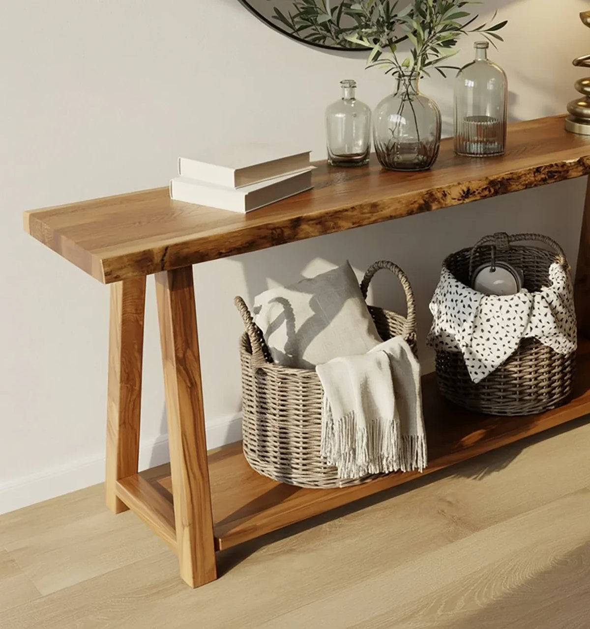 Wooden console table with decorative glass vases, books, and woven baskets with pillows and a throw