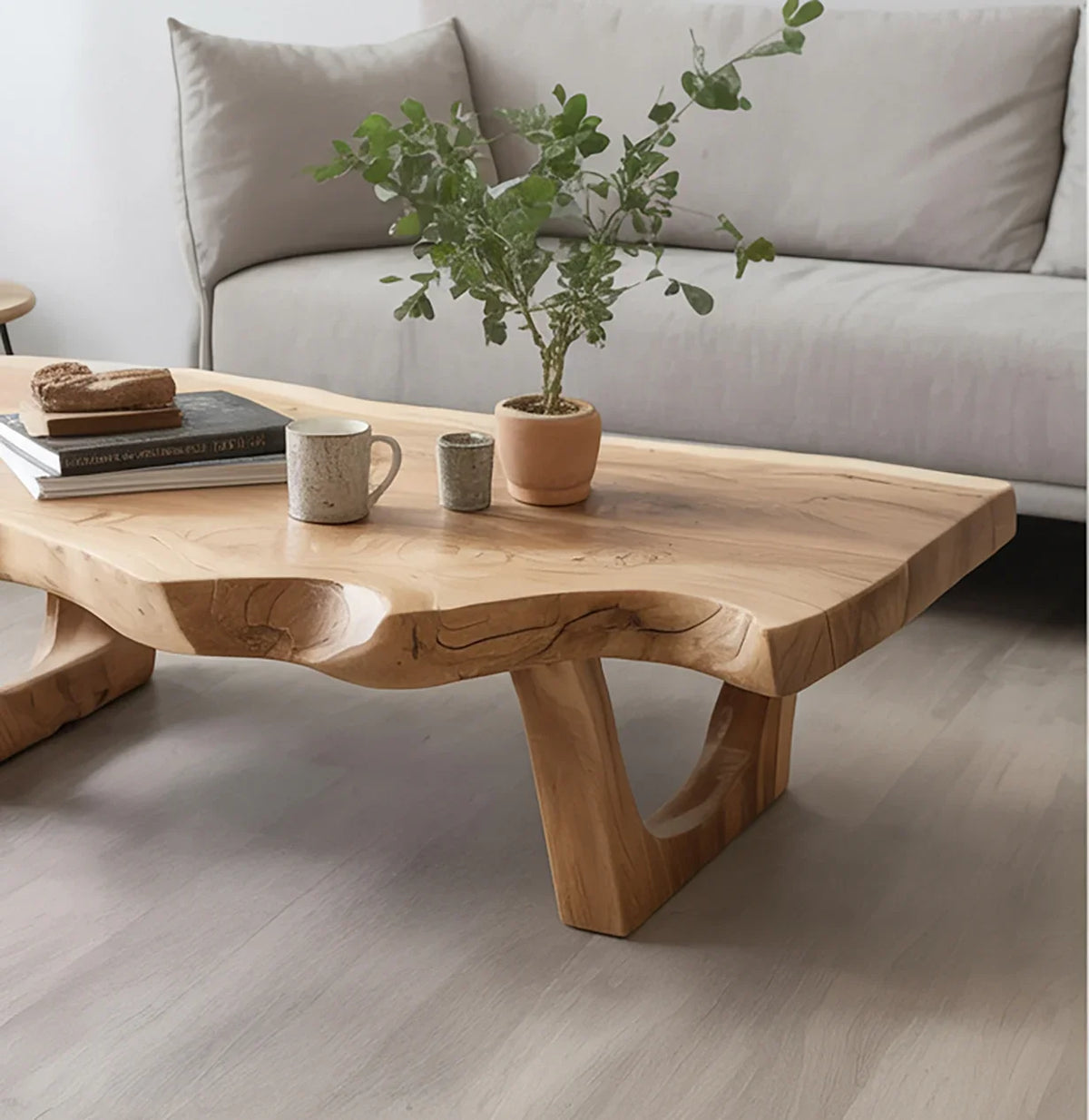 Live edge solid wood coffee table in modern living room, decorated with plant and mugs