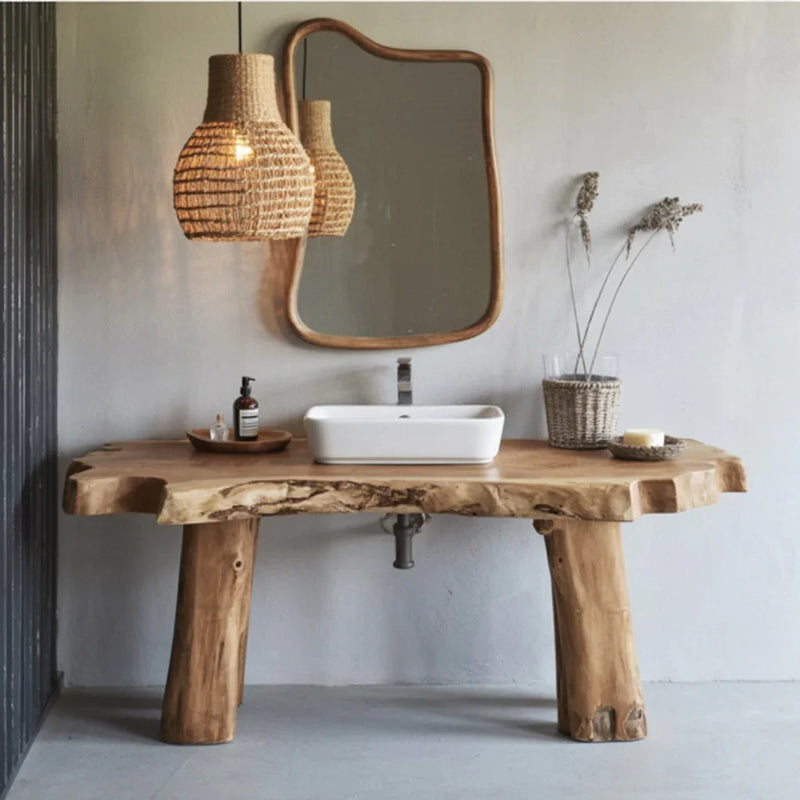 Rustic wooden bathroom vanity with white sink, natural wicker pendant light, and organic mirror