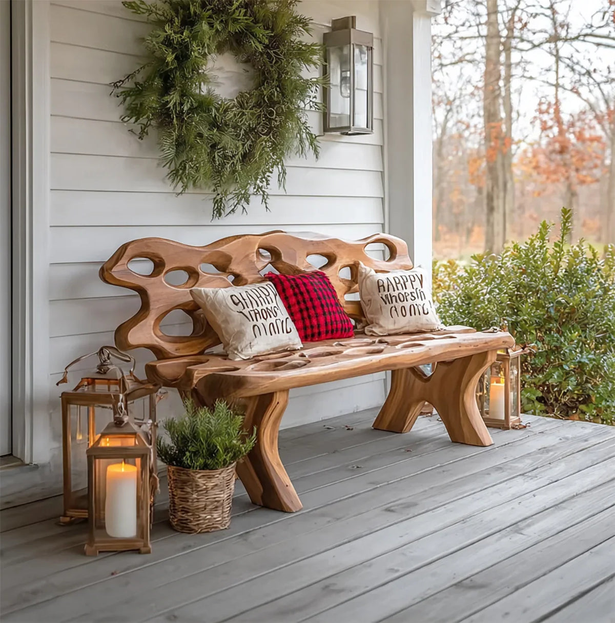 Rustic wooden bench on porch with holiday pillows, green wreath, lanterns, and potted plant