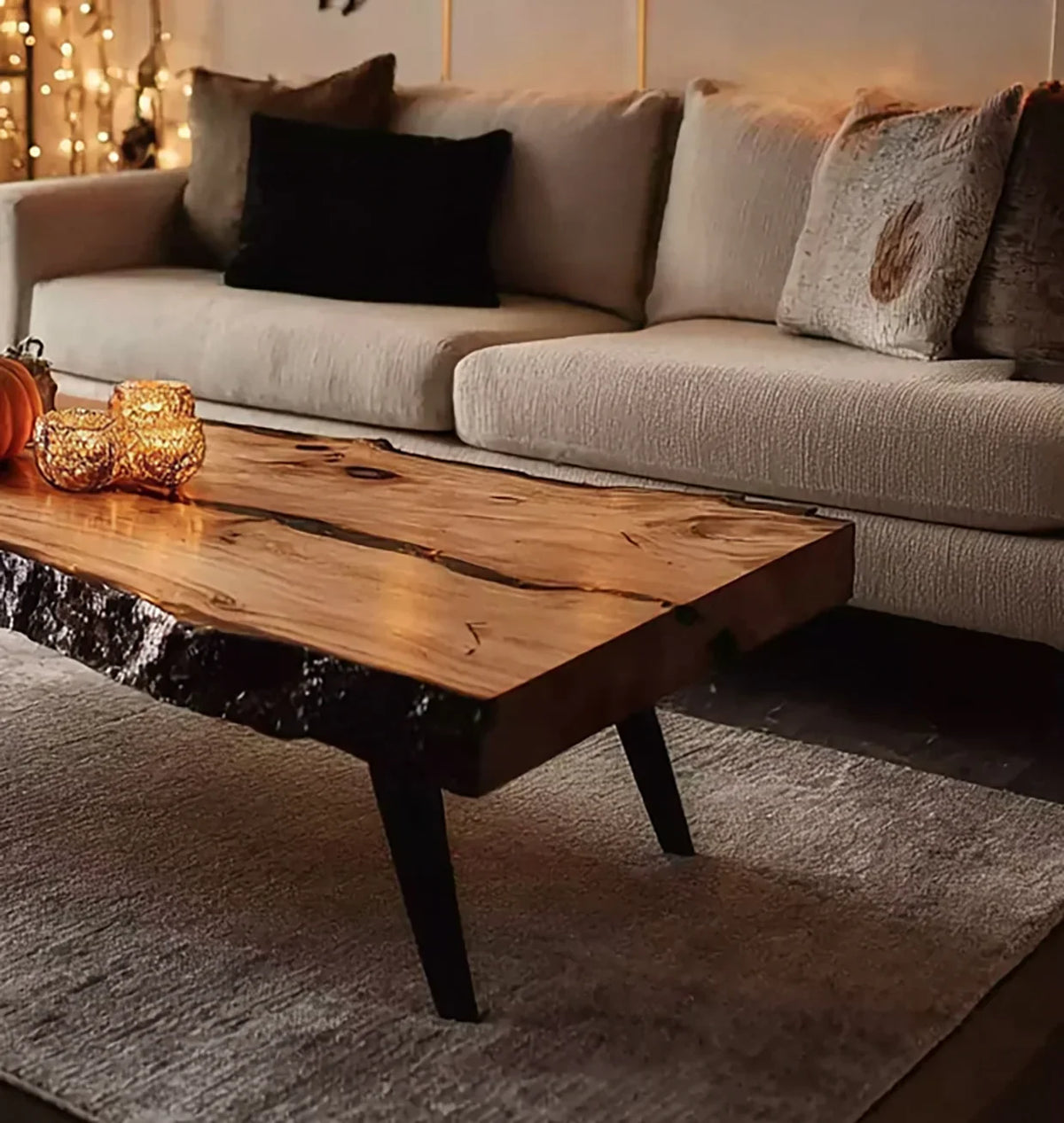 Cozy living room with beige sofa, textured pillows, rustic live edge wooden coffee table, candles, and soft lighting