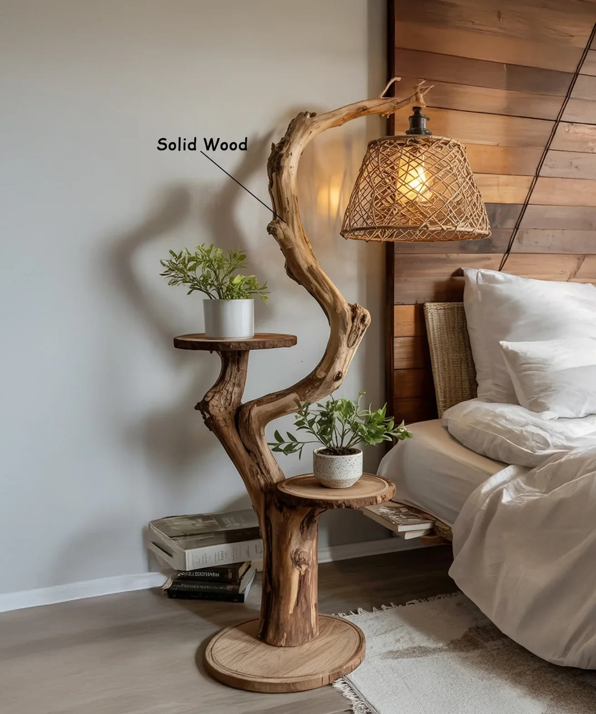 Solid wood tree bookshelf with branches, potted plants, and woven hanging lamp beside bed