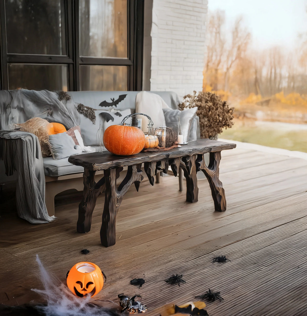 Rustic live edge wood coffee table with Halloween pumpkins and decorations on a porch