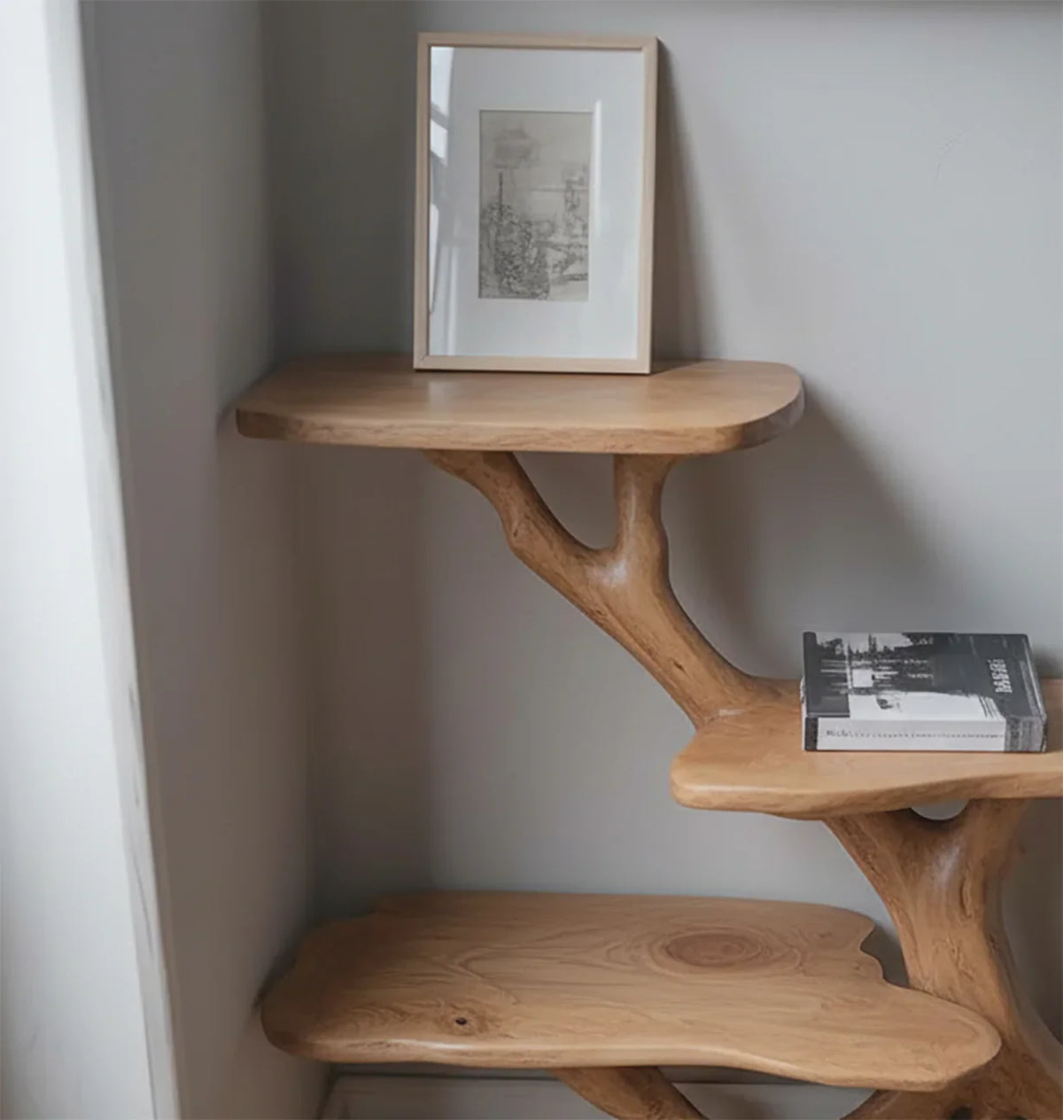 Solid wood tree bookshelf with natural live edge shelves, framed art, and book