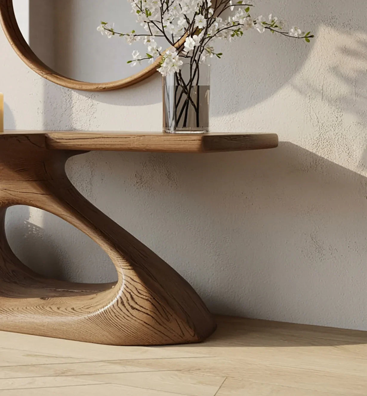 Modern sculptural wooden table with curved base, vase with white flowers, round wall mirror