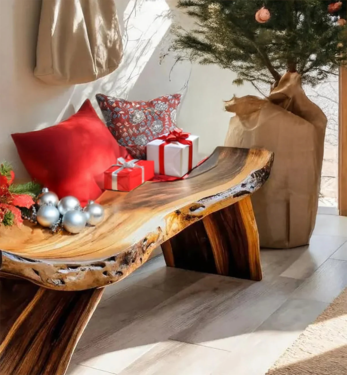 Rustic wooden bench with red and patterned pillows, Christmas gifts, ornaments, and a decorated tree in a sunny room