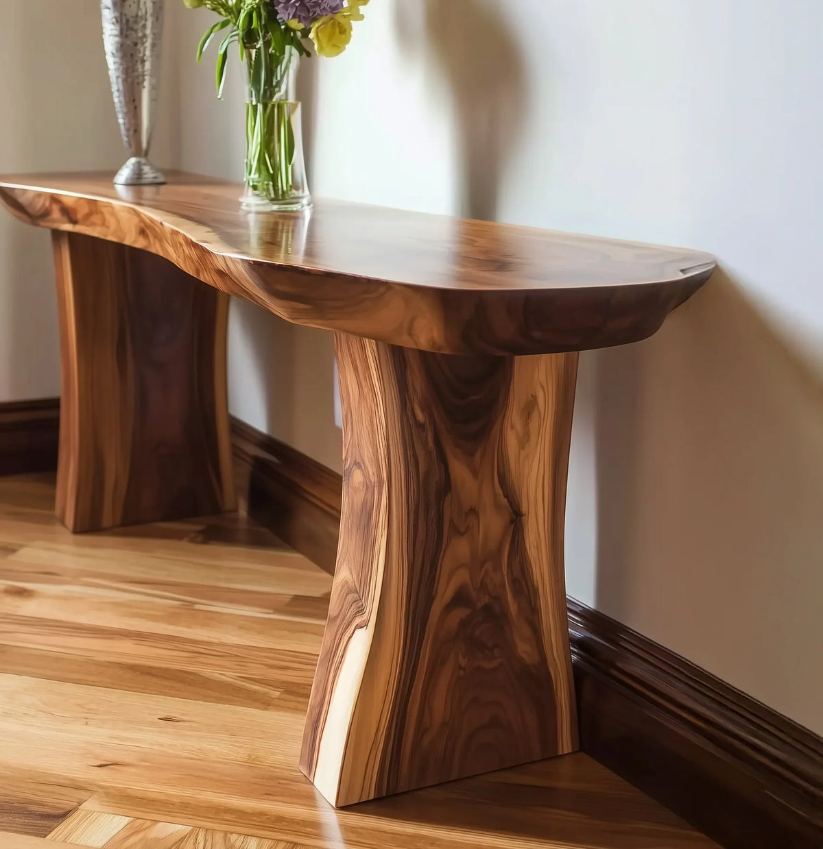 Live edge wooden bench with rich grain, placed on hardwood floor against white wall, decorated with flowers