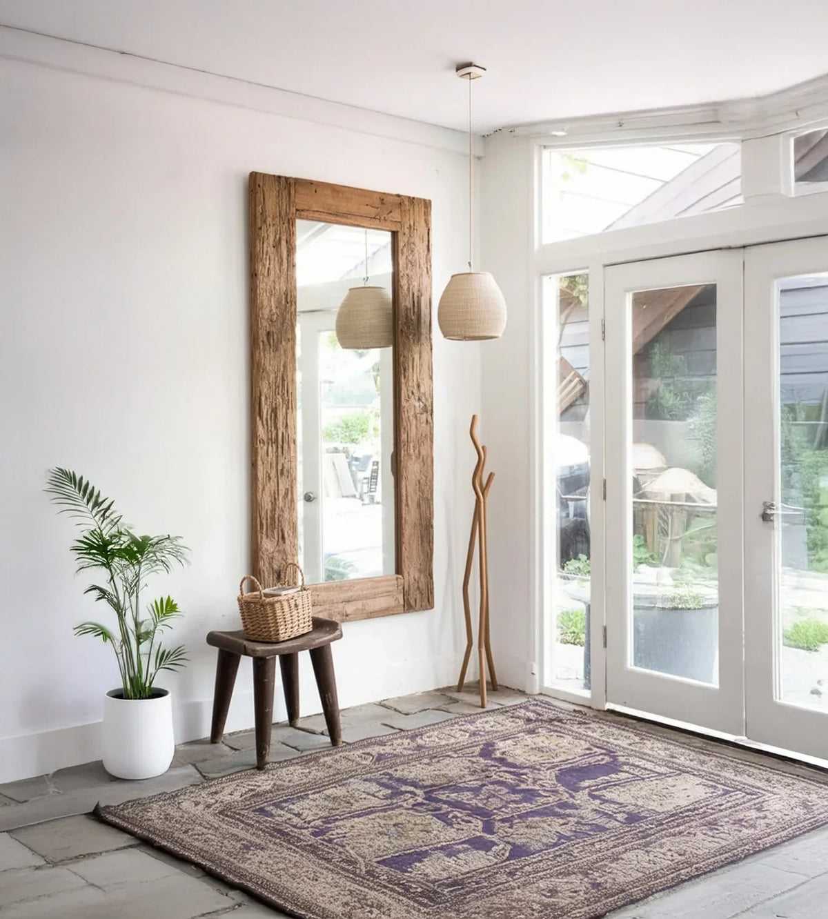Modern entryway with rustic wood mirror, live plant, accent bench, and patterned area rug