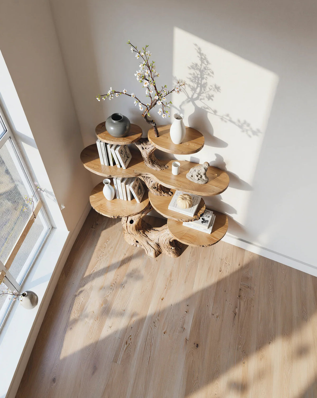 Solid wood tree bookshelf with live edge shelves, books, vases, decor in sunlit modern room