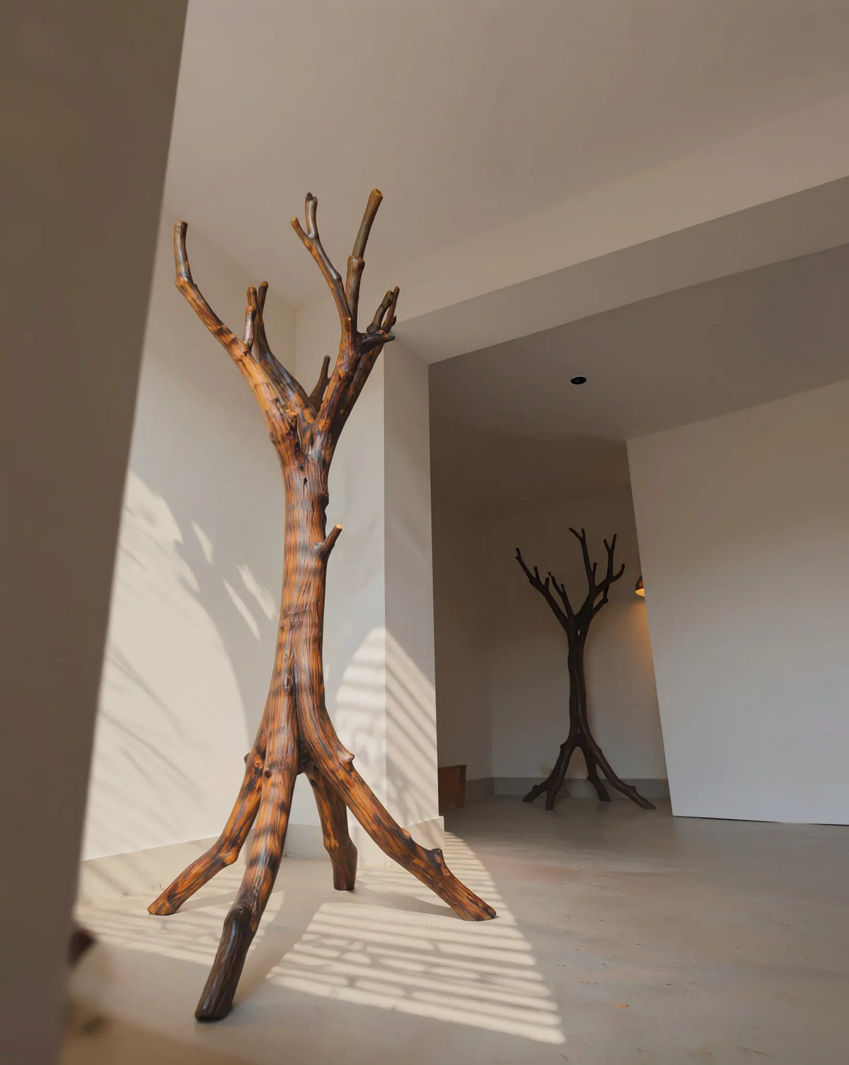 Sculpted solid wood tree bookshelf in modern minimalist room, natural live edge furniture