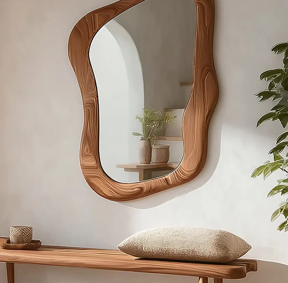Organic live edge wood mirror above a solid wood bench with cushion in a cozy entryway