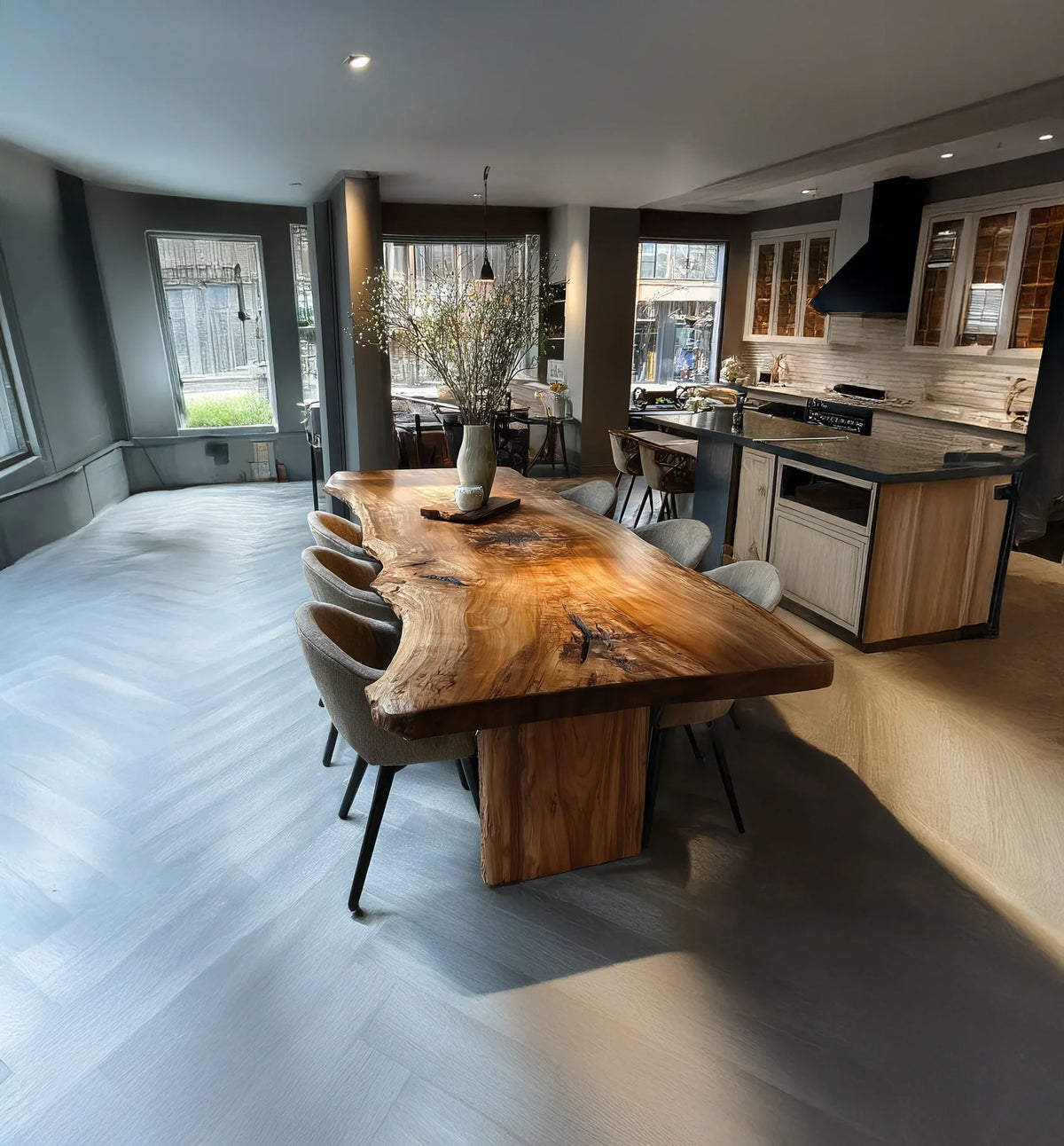 Modern kitchen with live edge wooden dining table and grey upholstered chairs under natural light