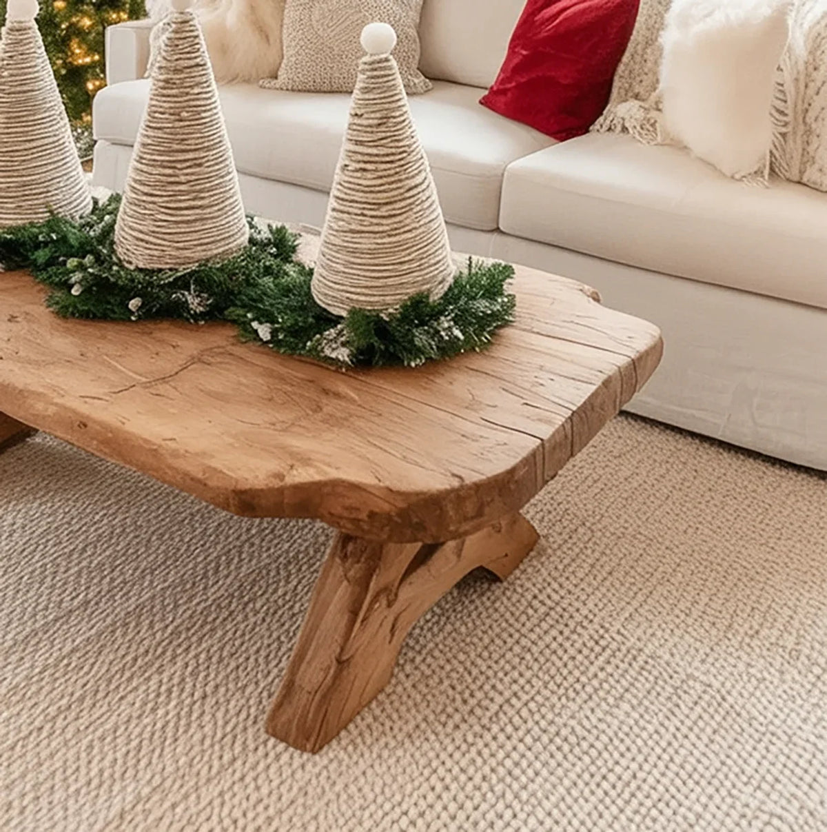Rustic wooden coffee table with wrapped cone Christmas decorations and greenery in cozy living room