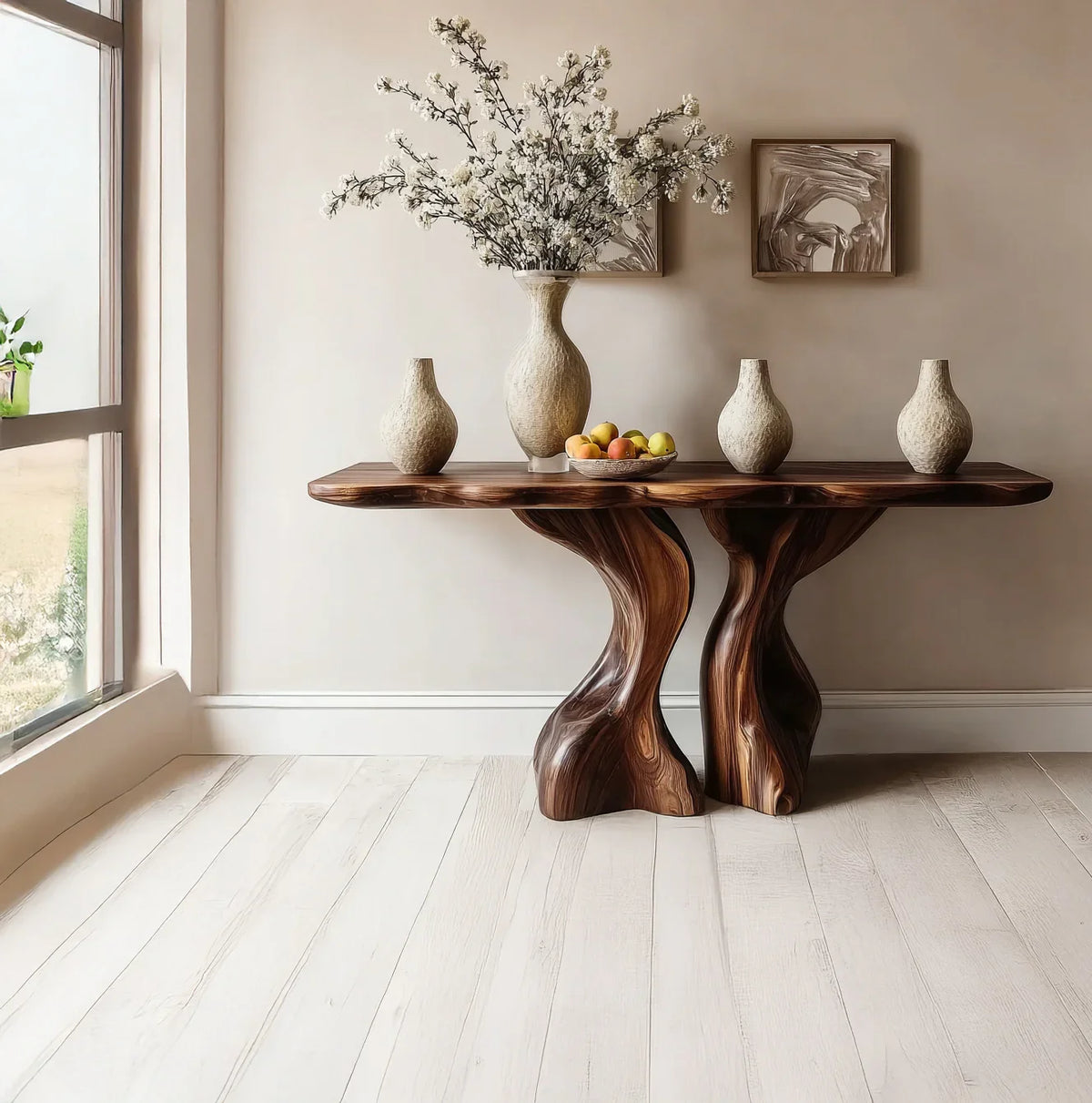 Wooden console table with sculptural base holding four beige ceramic vases and a fruit bowl in minimalist interior