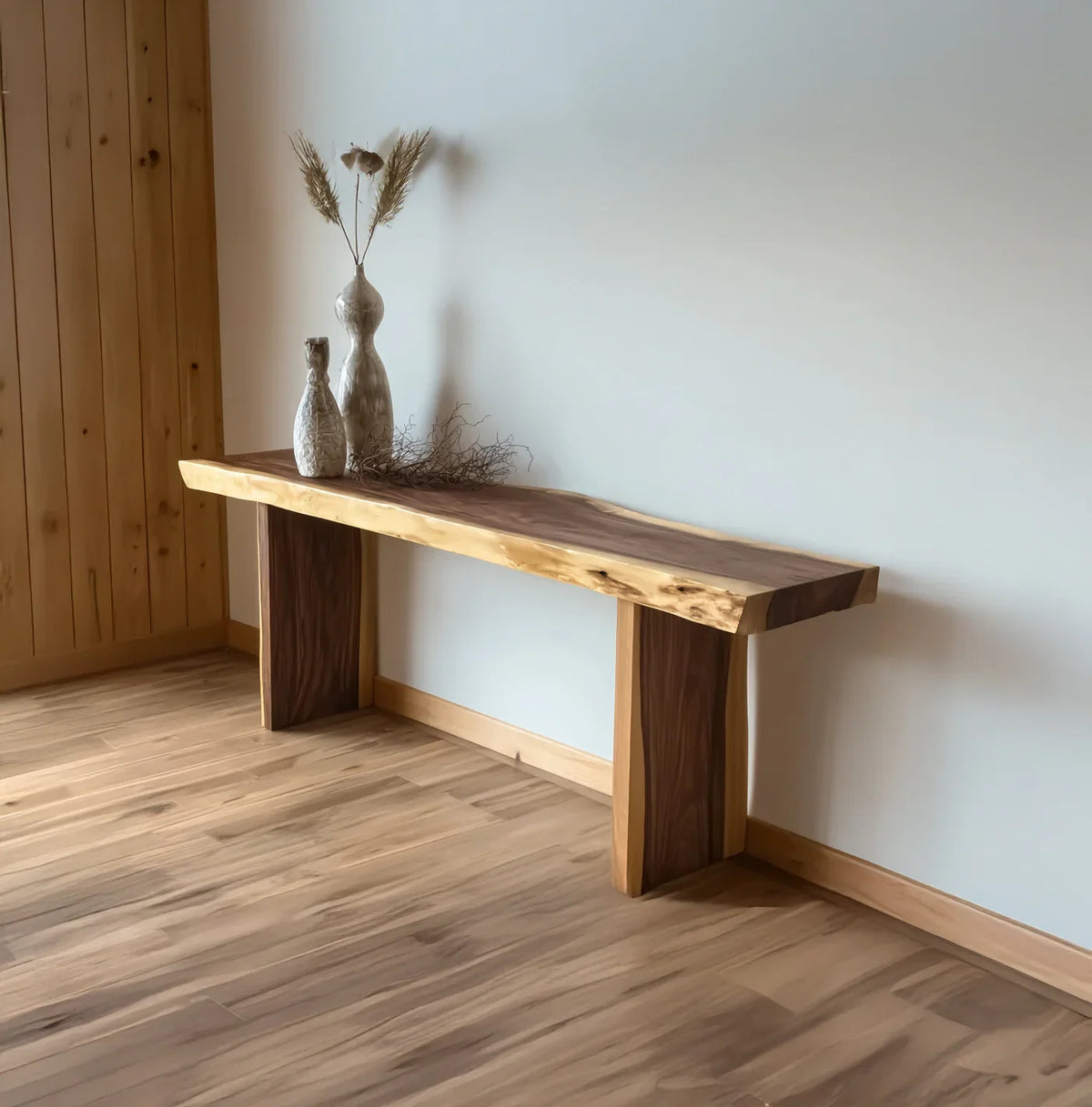 Live edge solid wood bench in minimalist room with vases and dried botanicals