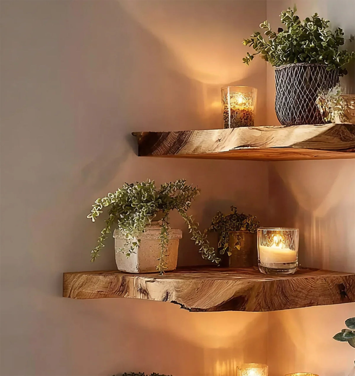 Wooden floating shelves with potted green plants and lit glass candles on a beige wall