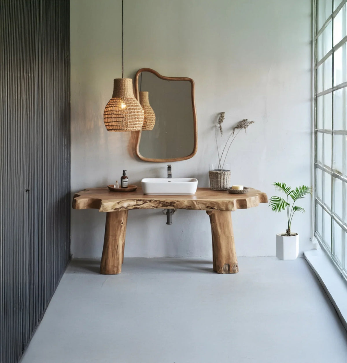Rustic wooden bathroom vanity with white vessel sink, woven pendant light, and natural decor