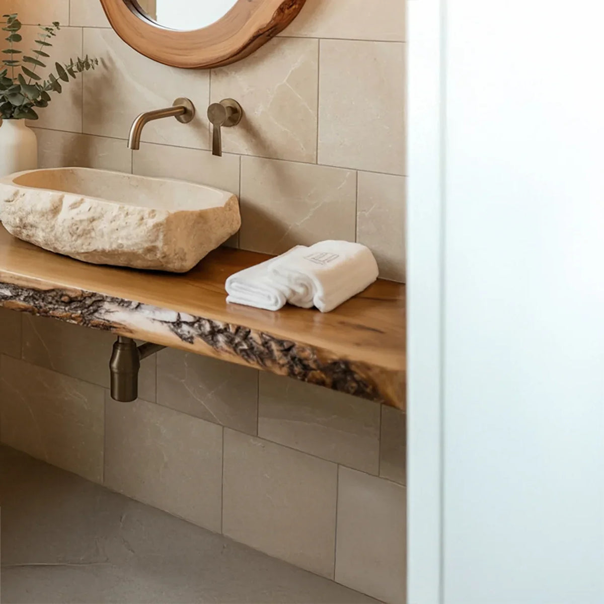 Live edge wood bathroom vanity with stone vessel sink and wall-mounted faucet