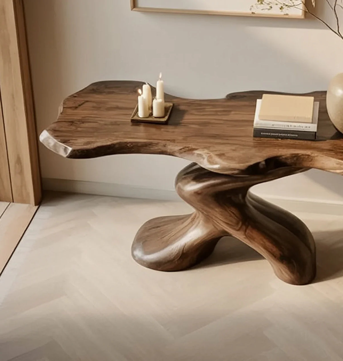 Live edge solid wood coffee table with sculptural base, candles, and books in a modern room