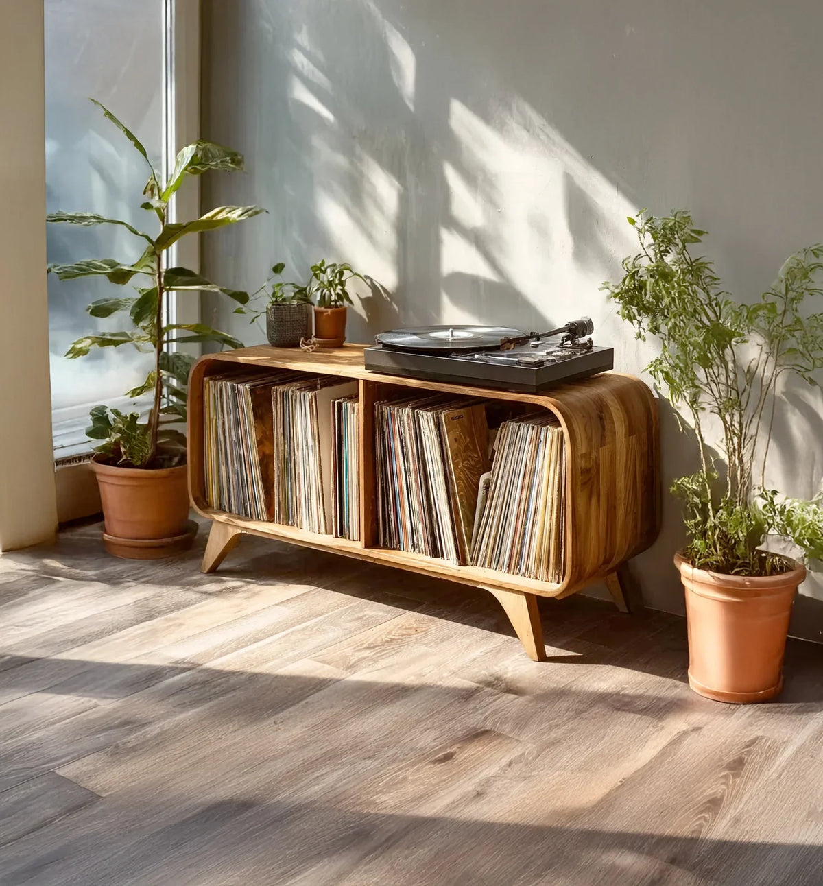 Wooden mid-century modern record player console with vinyl collection and houseplants in sunlit room