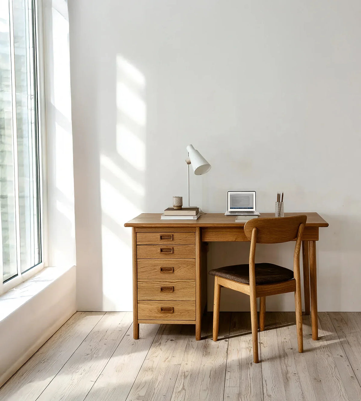 Solid wood desk with drawers and chair in minimalist home office, natural light