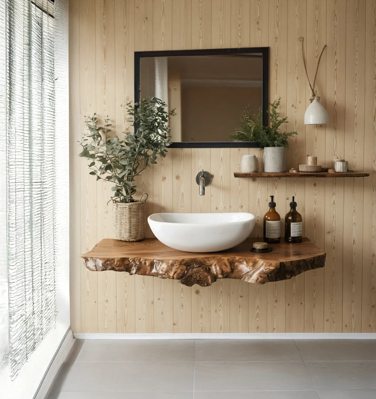 Modern bathroom with wood-panel wall, natural live-edge wood sink counter, white basin, decorative plants, and dark mirror