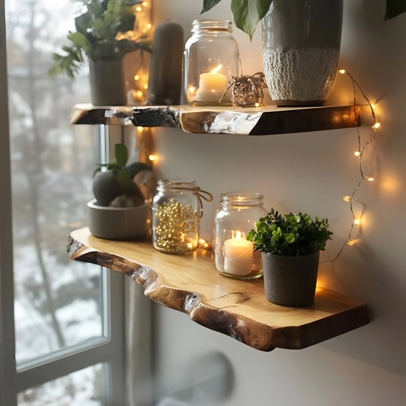 Two natural wood floating shelves with potted plants, candles in glass jars, and string fairy lights by a window