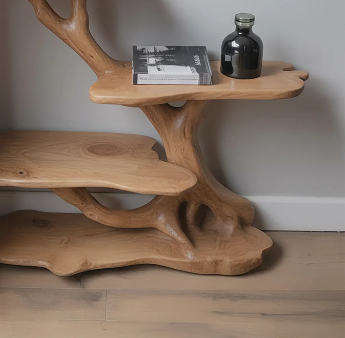 Live edge wooden tree bookshelf with natural shelves, book, and decorative bottle