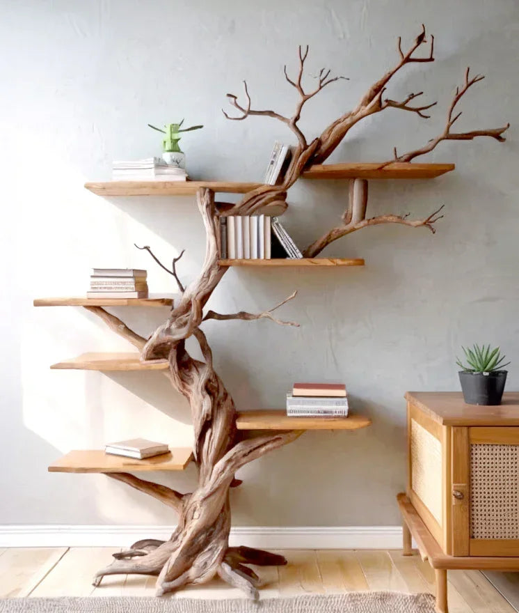 Live edge tree bookshelf with branches, books, and potted plants in a modern room