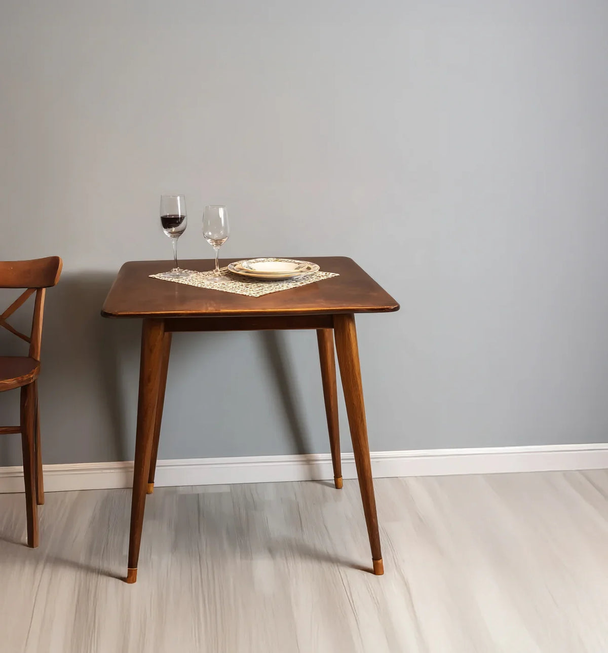 Solid wood square dining table with tapered legs, set for two, minimalist decor